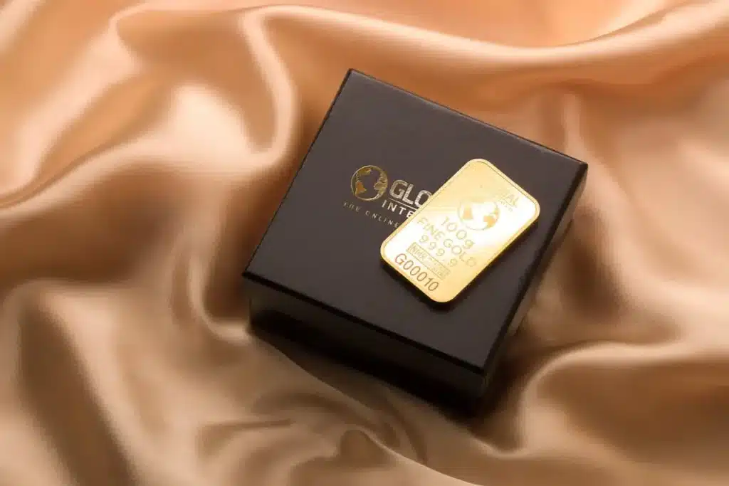 A 100g gold bar placed on a luxury black box, symbolizing financial success and wealth-building through smart investing and digital tools.
